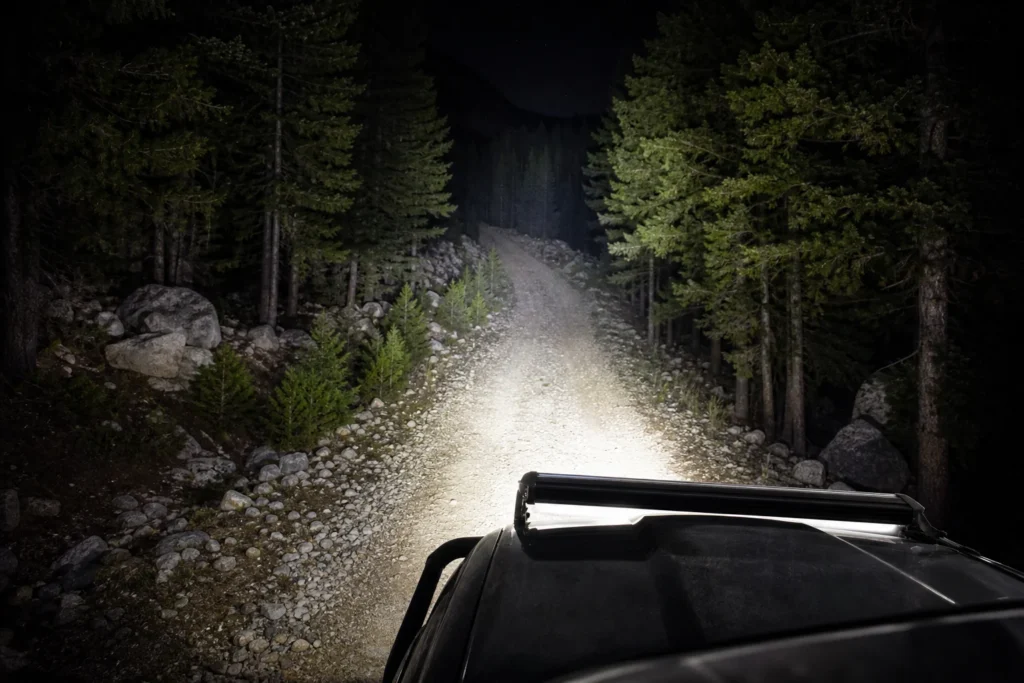 Off-road LED light bar shining across a trail with lumen output beam spread and distance comparison