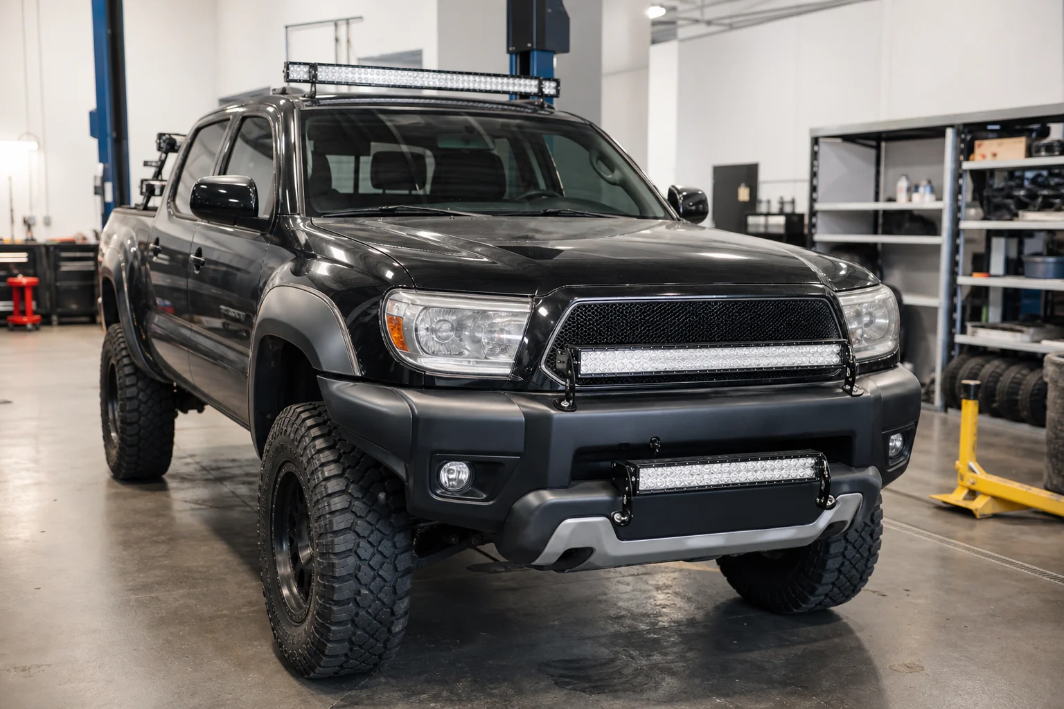 Off-road pickup truck in a workshop with LED light bars positioned near the grille, bumper, and roof rack for fitment comparison