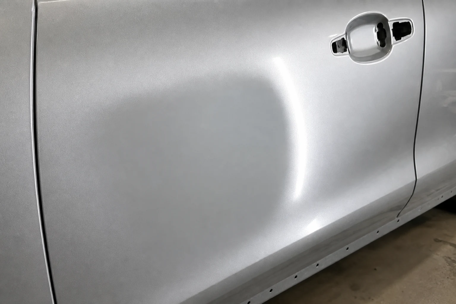 What is Feathering in Auto Body Work? How to Feather Sand Paint Edges 5 Smooth primer repair on a silver car door checked with a reflected inspection light for edge mapping