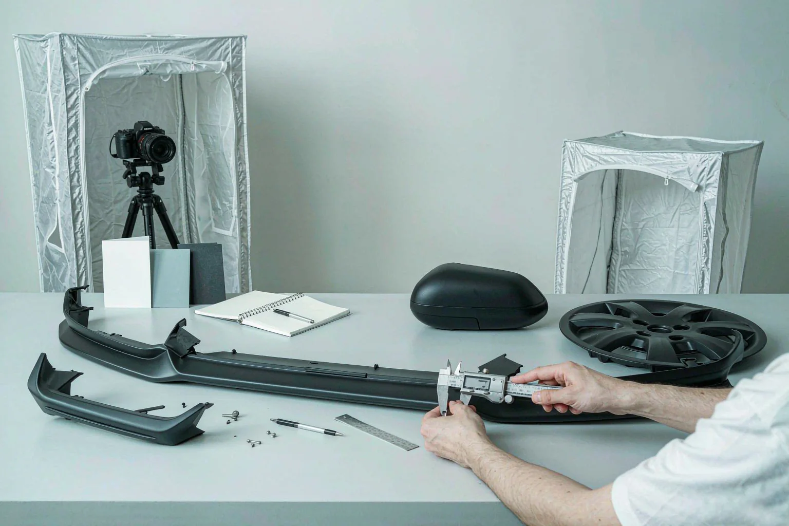 Solutions 4 Measuring a front lip sample with a digital caliper on a product development desk