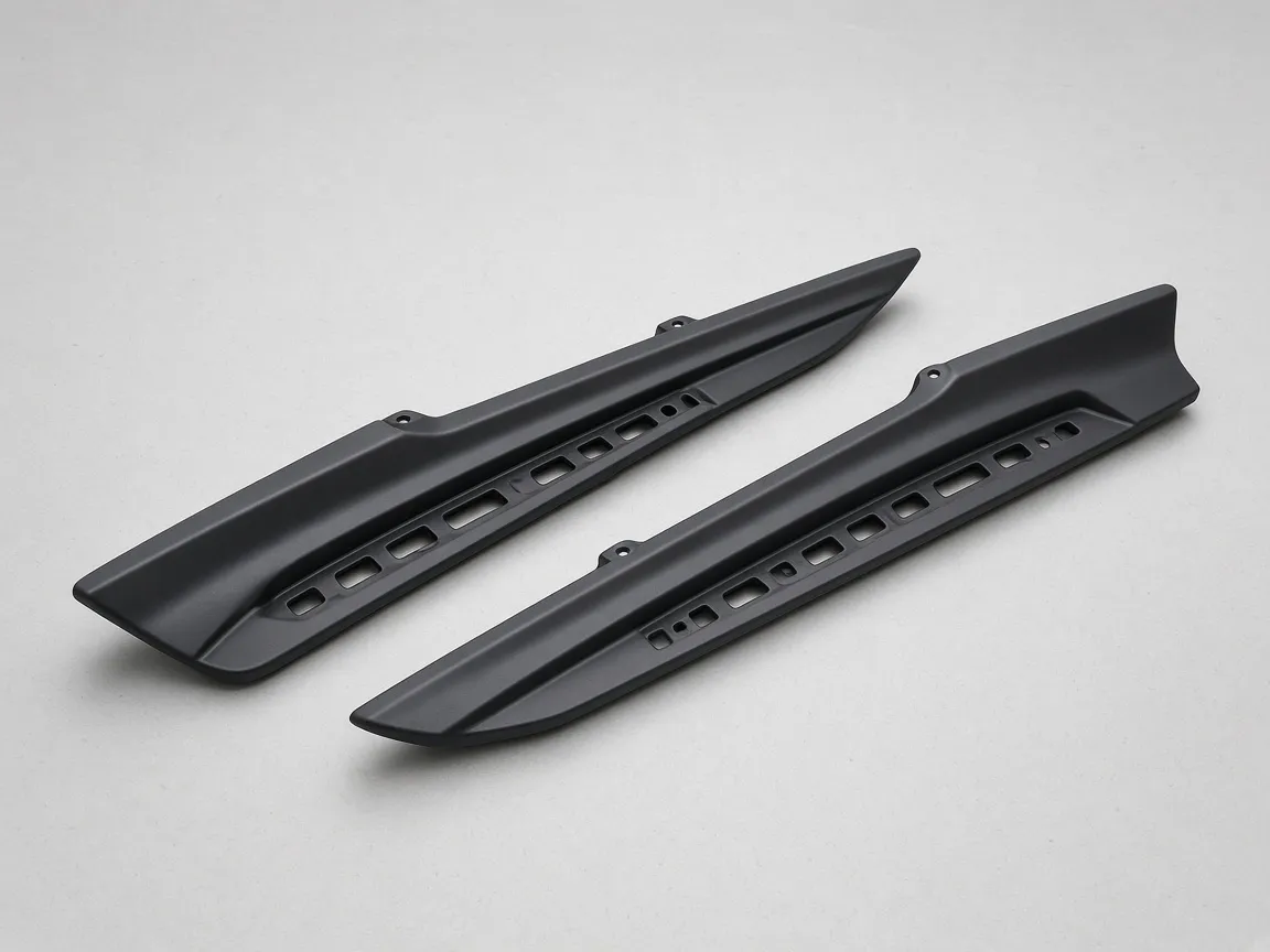 PP Plástico y TPO para Parachoques de Automóvil y Piezas Exteriores 9 Pair of black plastic side skirt extensions on an inspection table