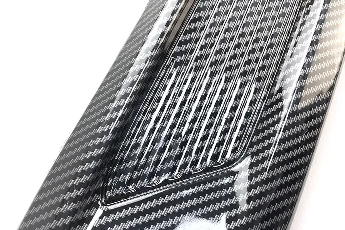 Carbon Fiber vs ABS vs Fiberglass Spoilers: Materials, Durability and Cost 1 Close-up of a glossy carbon-pattern weave finish on a molded car part