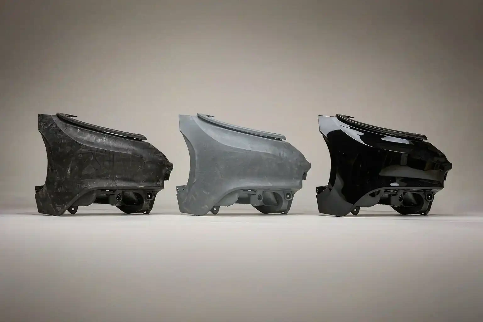 Three fender flares: raw molded-in color, grey primed and painted gloss black