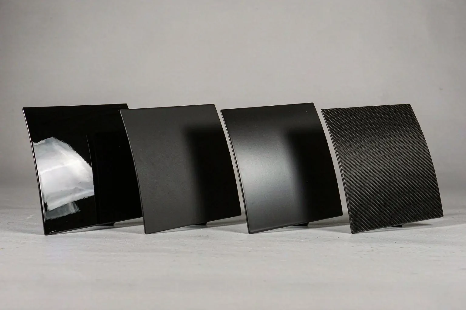 Materials & Finishes 1 Four curved sample panels in gloss black, satin black, matte black and carbon pattern