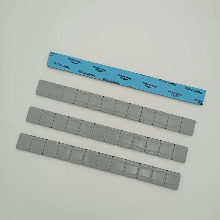 4 oz adhesive wheel weight strips laid out with blue tape