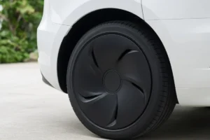 Rueda trasera de un crossover eléctrico blanco equipado con una cubierta de rueda aerodinámica negra mate
