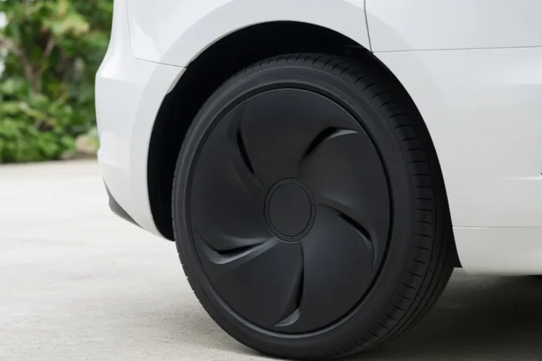 Rueda trasera de un crossover eléctrico blanco equipado con una cubierta de rueda aerodinámica negra mate
