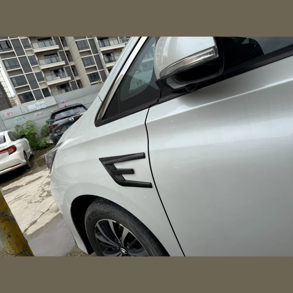 Carbon-fibre pattern shark gill trim installed on the front fender of a white car