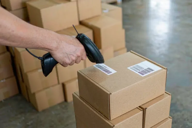 Scanning the barcode label on an auto parts carton before shipment